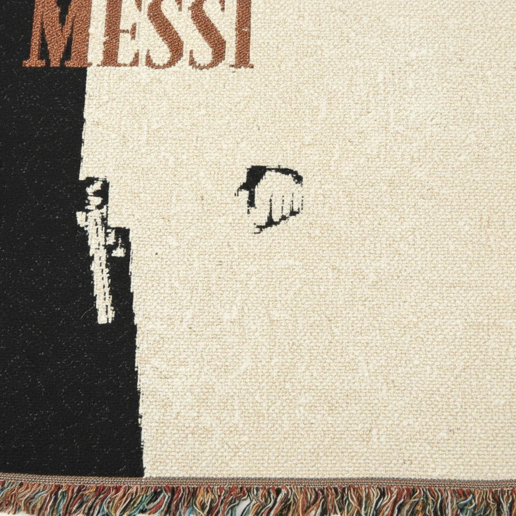 Futbol Addict Messi Scarface woven cotton blanket featuring a black and cream design with colorful fringed edges.